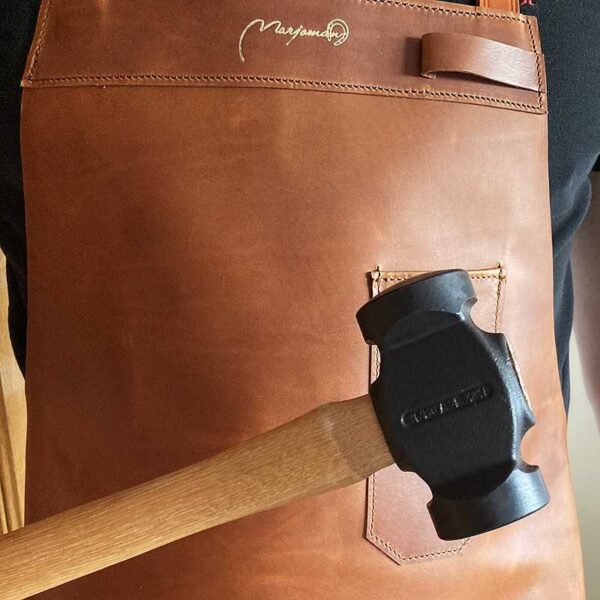 Detalle de bolsillo del mandil claro con martillo de muestra
